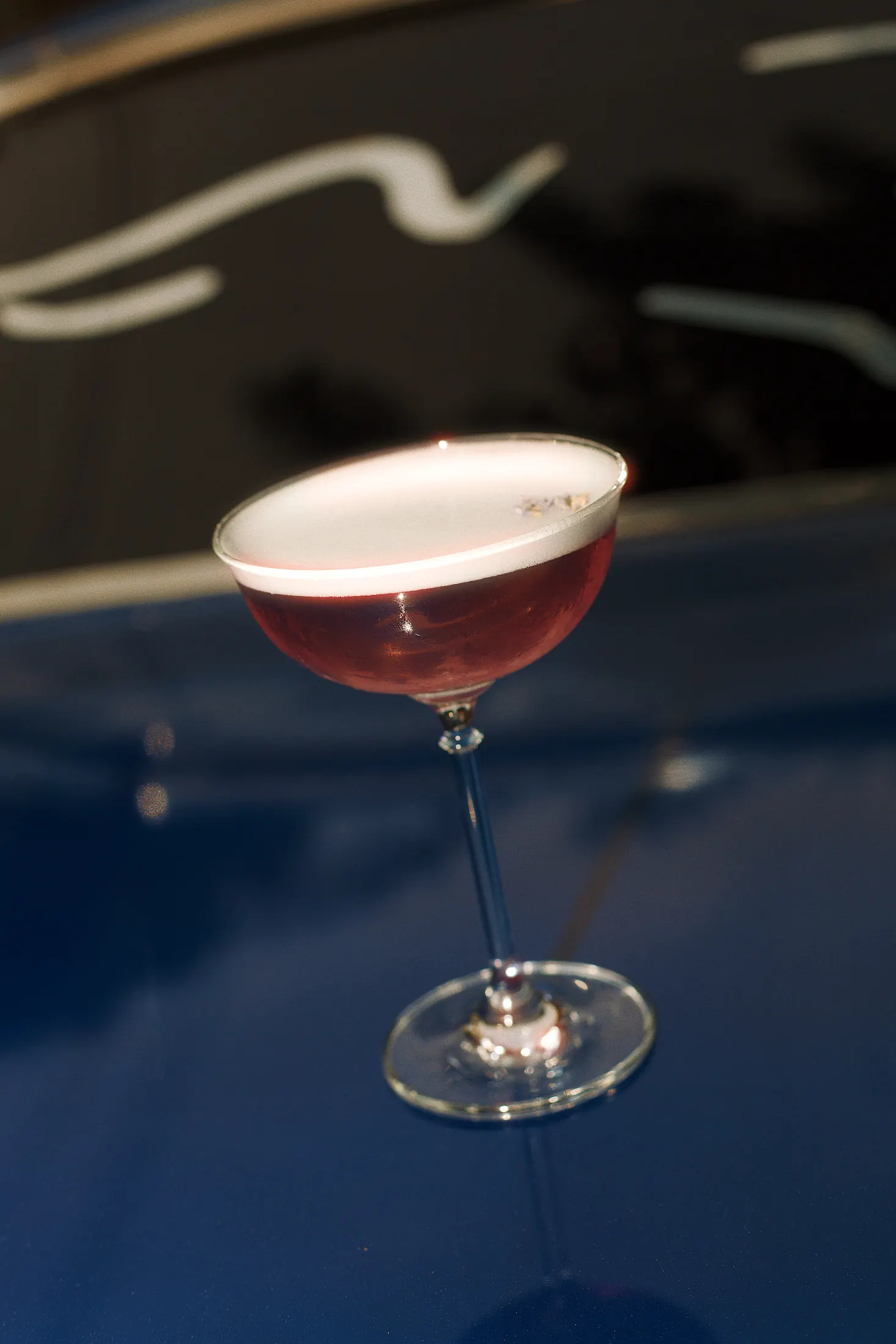 Cocktail reflected on a blue bar top