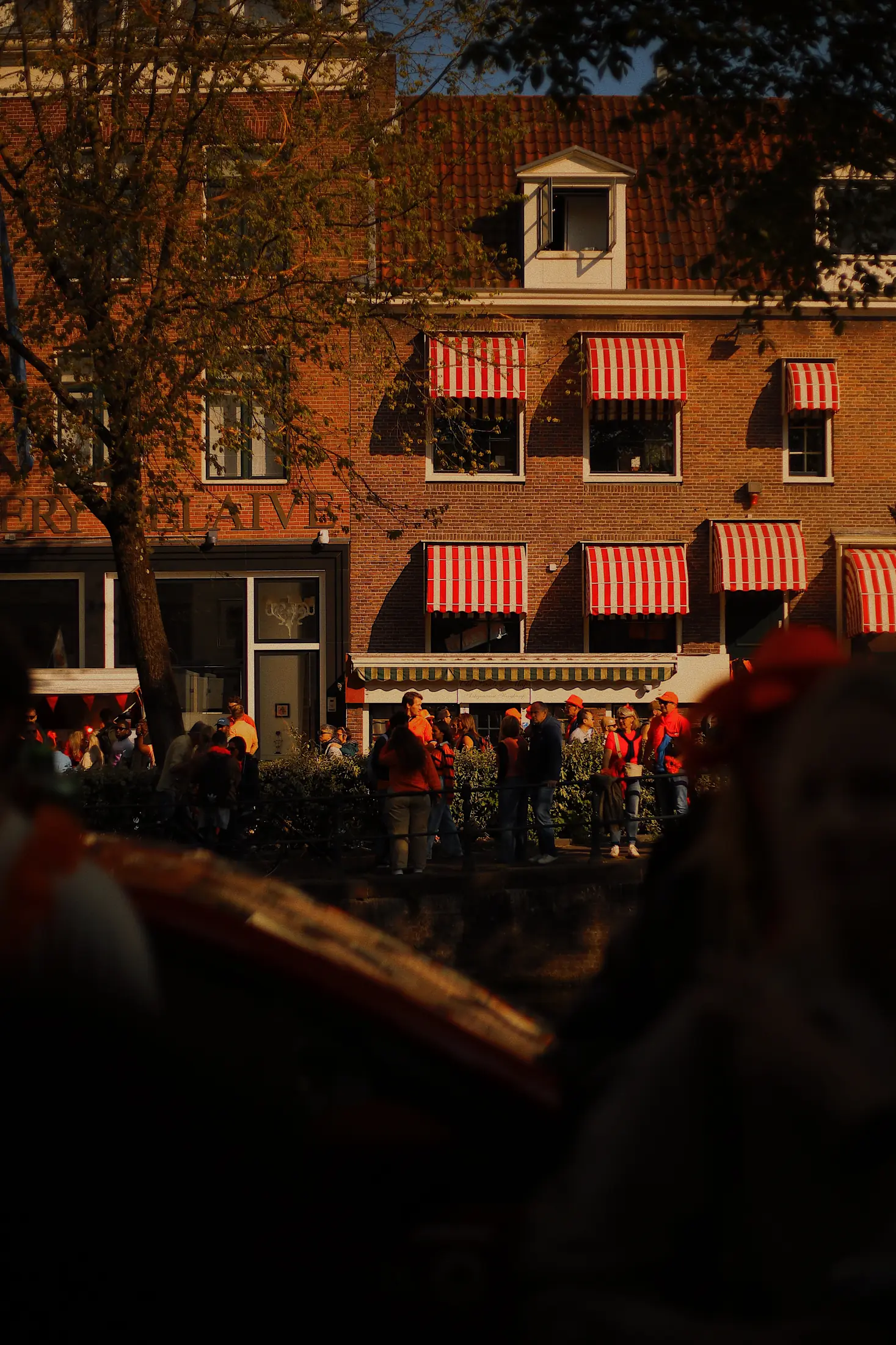 Striped awnings and a crowd at dusk